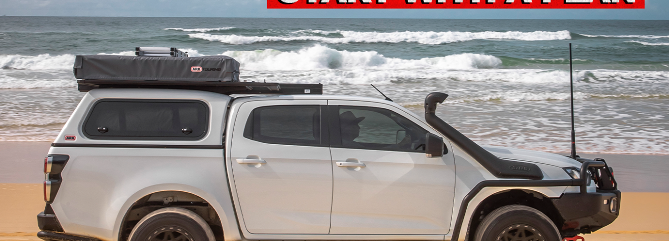 Isuzu D-MAX driving along a beach during a touring and remote travel adventure