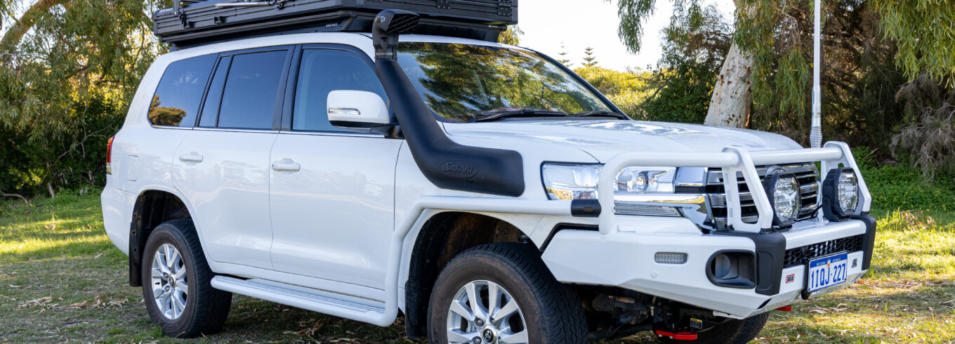 White Toyota LandCruiser 200 Series fitted with an ARB Summit bull bar, Safari snorkel, Intrepid rooftop tent and touring accessories.