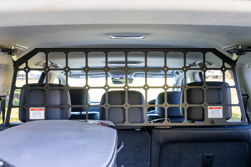 cargo barrier installed behind the second-row seats of a Toyota LandCruiser 200 Series.