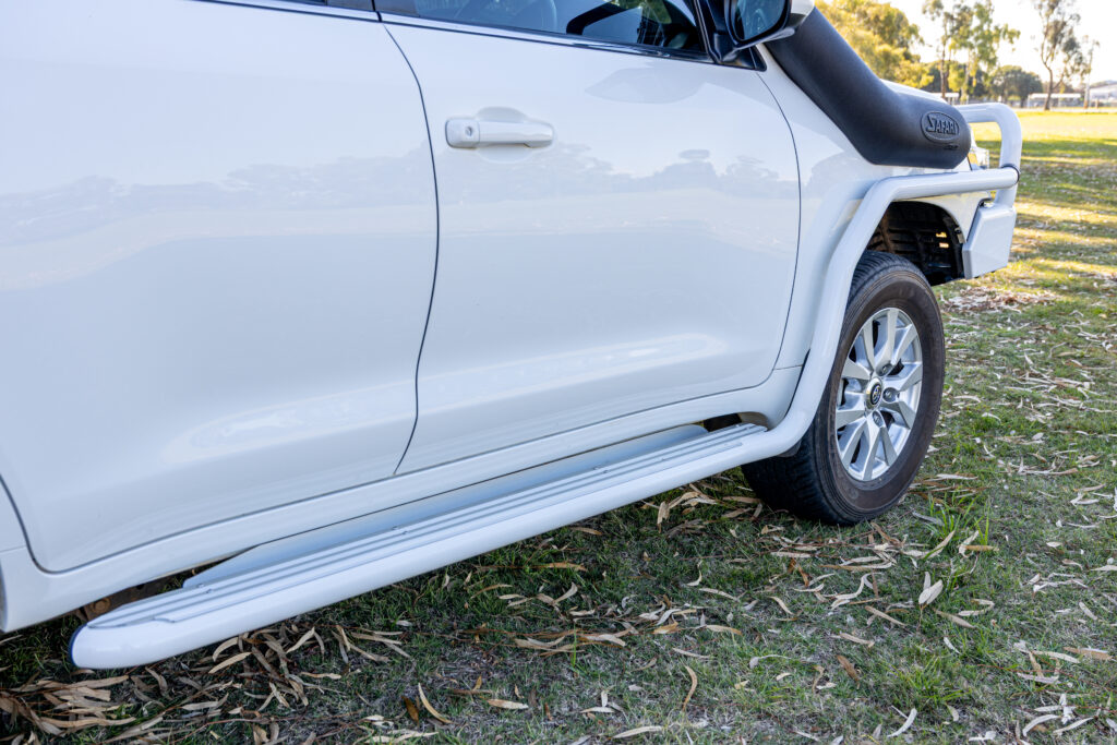 ARB side protection and side steps fitted to a white Toyota LandCruiser 200 Series.