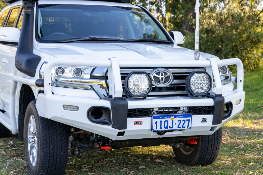 Front view of a Toyota LandCruiser 200 Series featuring an ARB Summit bull bar, Night Hawk driving lights and GME antenna.