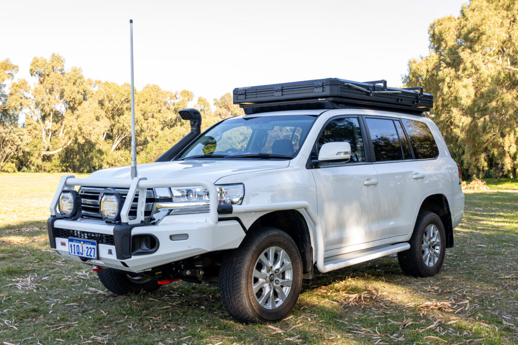 Front three-quarter view of a Toyota LandCruiser 200 Series with ARB touring accessories and rooftop tent installed.