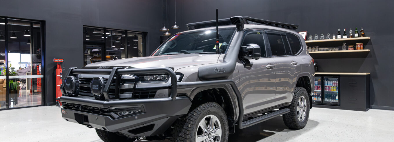 Front three quarter view of Rick's Toyota LandCruiser 300 Series fitted with an ARB Summit MKII Bull Bar, Bushranger Nighthawk driving lights and Safari snorkel.