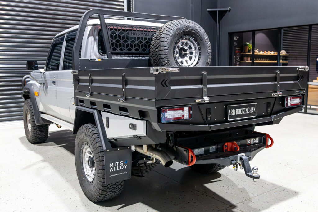 Rear angle of a Toyota LandCruiser 79 Series showing the MITS Alloy tray, undertray toolboxes, recovery points and spare wheel carrier.