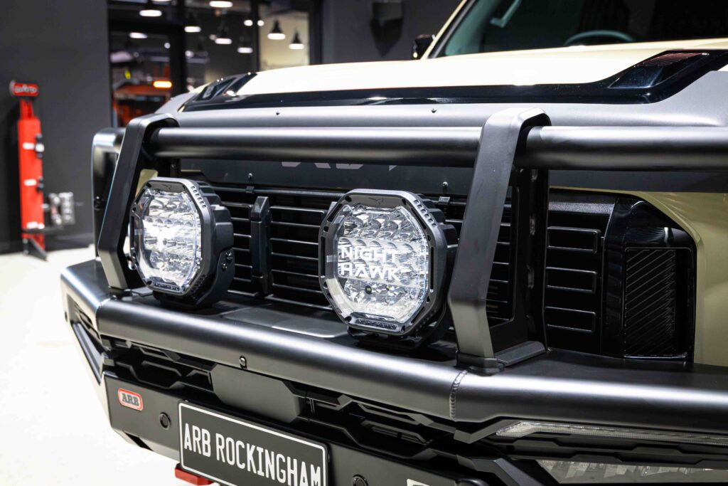 Front view of a Kia Tasman with ARB Summit MKII Bull Bar and Bushranger Night Hawk 9 inch driving lights