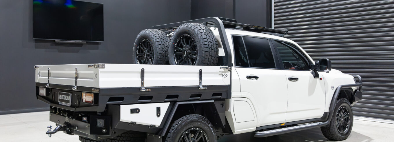 Rear three-quarter view of Tania’s chopped Toyota LC300 with MITS Alloy tray and twin spare wheel setup