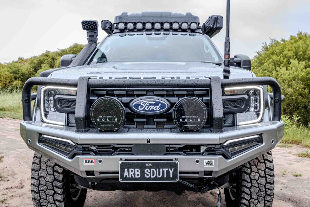 Front view of a Ford Super Duty fitted with an ARB Summit MKII Bull Bar, ARB Solis driving lights and roof-mounted Nacho Quatro spotlights