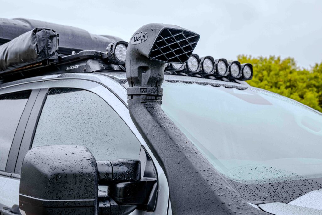 Close-up of the snorkel fitted to the Ford Super Duty touring build with roof-mounted lighting visible behind