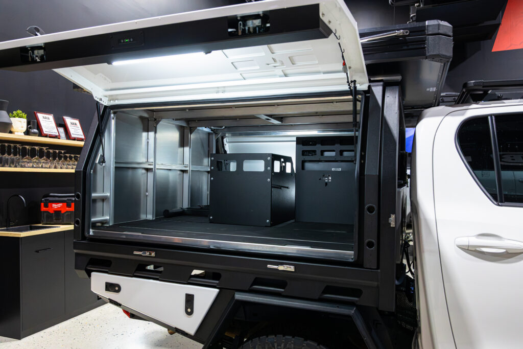 Interior view of the MITS Alloy canopy fitted to Michael’s Toyota Hilux showing modular storage and open cargo space