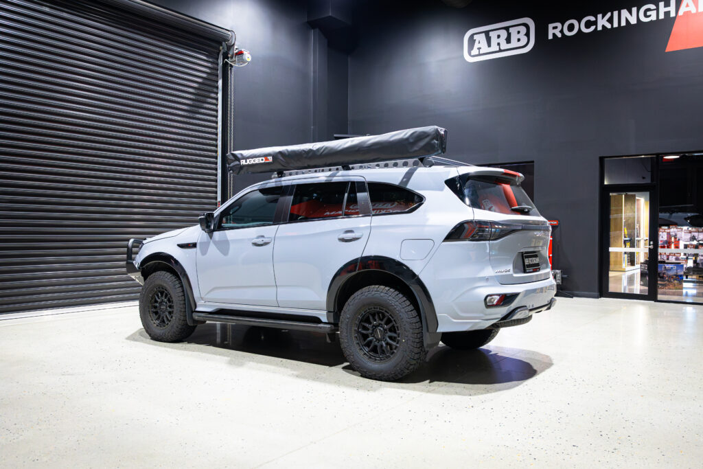 Rear three-quarter view of Liam’s Isuzu MU-X fitted with a Rhino-Rack Backbone and Sportz Bars at ARB Rockingham